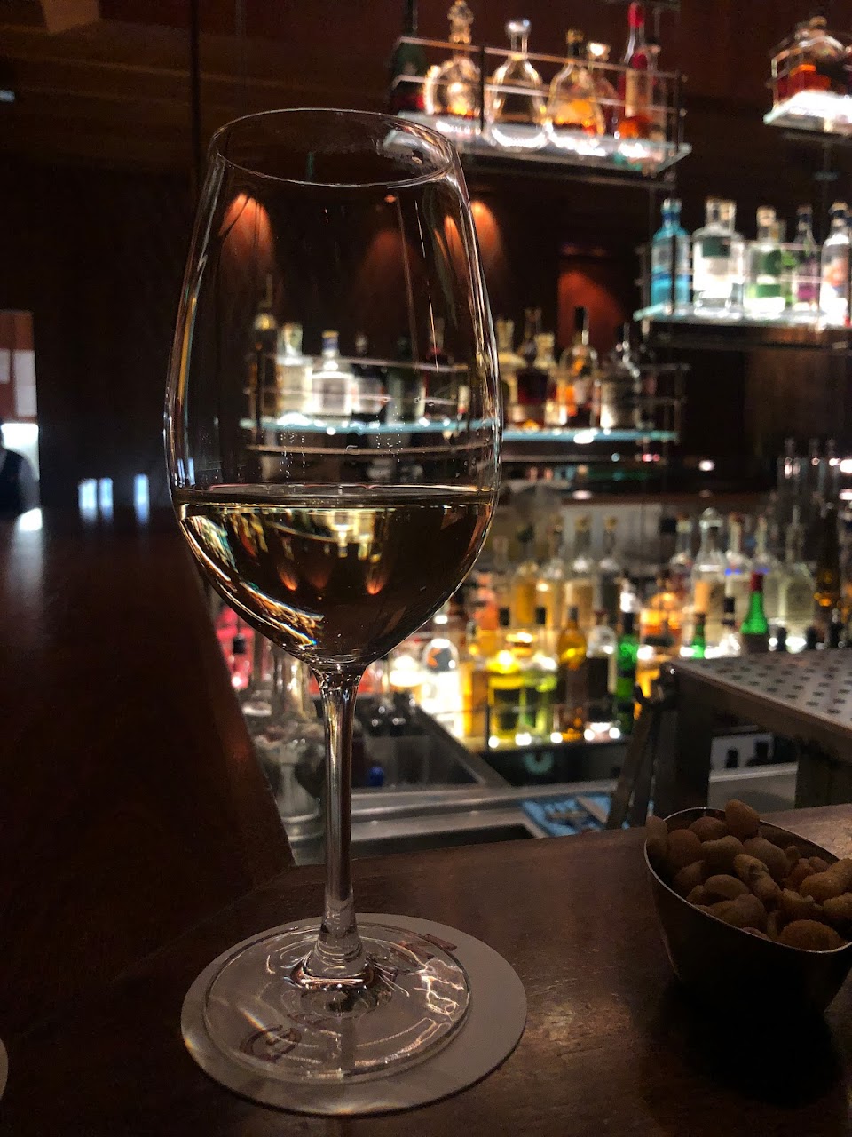 Wine glass on the Grain Bar counter with the back bar behind